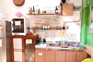 a small kitchen with a sink and a microwave at Fuqi Hostel - Yuanqi in Tainan