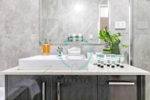 a bathroom with a white sink and a mirror at Zenhouse: 4BR Stylish Work/Family Home in Muirhead in Leanyer +53 photos