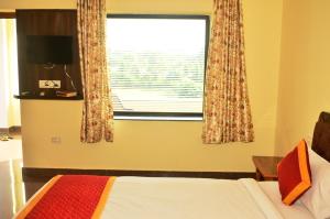 1 dormitorio con cama y ventana en Motibagh Resort, en Sawāi Mādhopur