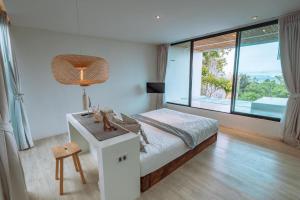 1 dormitorio con cama, escritorio y ventana en Myth Koh Larn resort bar and bistro, en Koh Larn