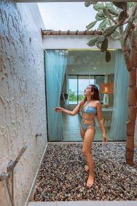 Una mujer en bikini parada en un baño en Myth Koh Larn resort bar and bistro, en Koh Larn