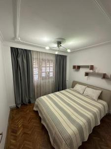 a bedroom with a large bed and a window at Bulevard Residence in Drobeta-Turnu Severin
