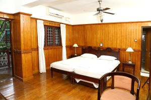 a bedroom with a bed and a ceiling fan at Walton's Homestay, Fort Cochin in Fort Kochi