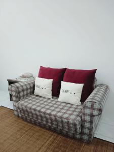 a couch in a living room with two pillows on it at Yussal Homestay in Simpang Ampat Semanggol