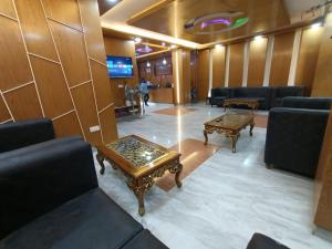 a waiting room with couches and tables in a lobby at Hotel D-Palace in Dhaka