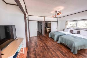 Harada的住宿－白浜大洋マンション，一间卧室配有两张床和一台平面电视