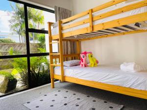 a bedroom with bunk beds with a view of the ocean at Spacious Mission Bay Villa 100m to the beach, seaview, private garden, Netflix in Auckland