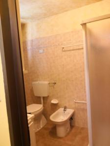 a small bathroom with a toilet and a sink at Appartamenti Rio Geandola 