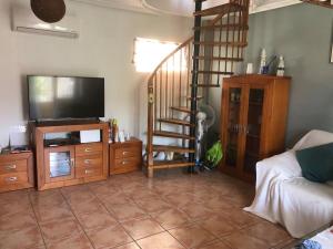 un salon avec une télévision et un escalier dans l'établissement By the sea, à Los Alcázares