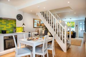 a kitchen and living room with a white table and chairs at Luxury Town House, Tavistock (sleeps 4) in Tavistock