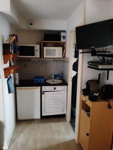 a small kitchen with a sink and a microwave at Appartement entre thermes et montagne in Luchon