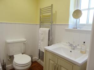 ein Badezimmer mit einer weißen Toilette und einem Waschbecken in der Unterkunft Pump Cottage in Weymouth