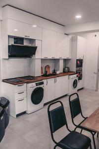 a kitchen with a washing machine and a table and chairs at Apple cozy hotel in Tbilisi City
