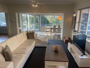 a living room with a white couch and a table at Banyan spacious three bedroom pet friendly property with air con in Nelson Bay