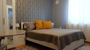 een slaapkamer met een bed met gele kussens en een tafel bij Crystal Room in Timişoara