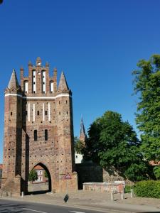 un vecchio edificio con una torre con cancello di Haus am Eichenwall, Fewo1, Residenz + Ferienwohnungen a Friedland