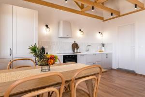 a kitchen with a table and chairs and a kitchen with white cabinets at Casa Oliva in Tsoukalades