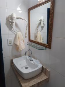 CASINHA AZUL/PIRINOPOLIS في بيرينوبوليس: حمام مع حوض أبيض ومرآة