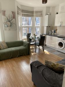 a living room with a couch and a table with chairs at Large, Bright and Spacious 3 Bed Flat in London in London