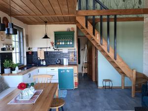 a kitchen with a wooden table and a staircase at Chatka na Wzgórzu in Morzyszów