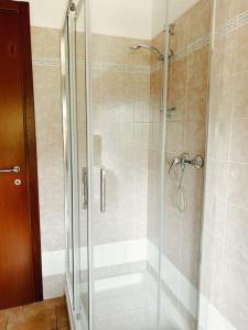 um chuveiro com uma porta de vidro na casa de banho em Bianchi &Bianchi casa vacanza Laveno-Mombello em Laveno