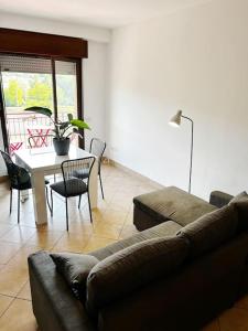 uma sala de estar com um sofá e uma mesa com cadeiras em Bianchi &Bianchi casa vacanza Laveno-Mombello em Laveno