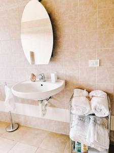 uma casa de banho com lavatório, espelho e toalhas em Bianchi &Bianchi casa vacanza Laveno-Mombello em Laveno