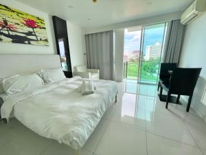 a bedroom with a white bed and a desk and chair at City Center Residence & Hot Hot Hot in Pattaya Central +16 photos