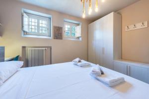 1 dormitorio con 1 cama blanca grande y 2 toallas en Casa Grace, en San Felice del Benaco