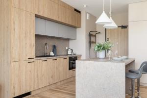a kitchen with wooden cabinets and a counter top at Tauron Arena Crakow Apartment with Parking by Renters in Krakow