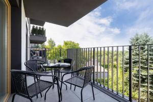a patio with a table and chairs on a balcony at Tauron Arena Crakow Apartment with Parking by Renters in Krakow