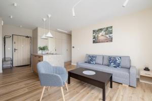 a living room with a couch and a table at Tauron Arena Crakow Apartment with Parking by Renters in Krakow