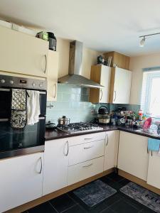 a kitchen with white cabinets and a stove top oven at DARTFORD CROSSING The BRIDGE PLACE - CONTRACTORS FAVOURITE in Kent