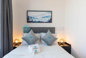a bedroom with a bed with white sheets and pillows at Classic 2 Bedroom In Oasis in Al Qurayyah
