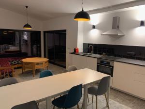 a kitchen with a table and chairs and a dining room at Casa Rio, Amalia in Ferreira do Zêzere