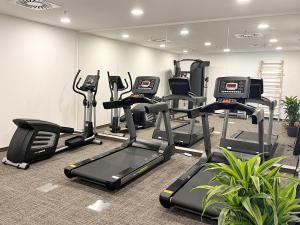 une salle de sport avec plusieurs tapis de course et machines elliptiques dans l'établissement DORMERO Hotel Budapest, à Budapest