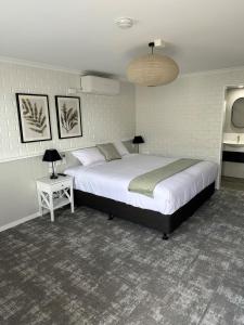 トゥーンバにあるThe Shamrock Hotelのベッドルーム1室(大型ベッド1台、ランプ2つ付)