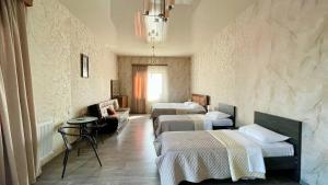 Habitación de hotel con 2 camas y lámpara de araña. en Hotel West Face, en Kutaisi