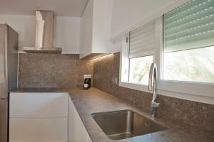 eine Küche mit einem Waschbecken und einem Fenster in der Unterkunft Acogedor apartamento junto al mar in Oliva