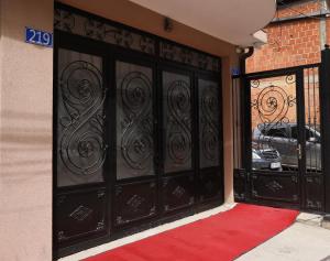 a black door with a red carpet in front of a building at Oldtown Apartment in Prishtina in Pristina
