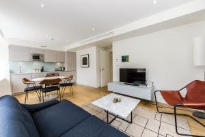 a living room with a blue couch and a kitchen at Native Tower Bridge in London