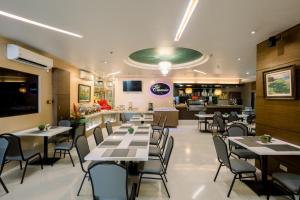 un comedor con mesas y sillas en un restaurante en Allure Hotel & Suites, en Cebú