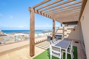 ein Tisch und Stühle auf einem Balkon mit Blick auf das Meer in der Unterkunft Marfolin 22 in Cotillo