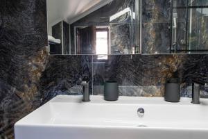 a bathroom with a sink and a mirror at Hostel Aurora in Požarevac