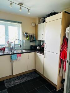 a kitchen with white cabinets and a sink at DARTFORD CROSSING The BRIDGE PLACE - CONTRACTORS FAVOURITE in Kent
