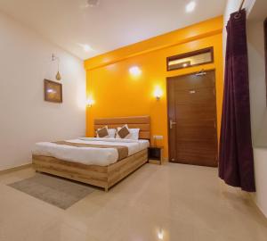 1 dormitorio con 1 cama con pared amarilla en The Hideout Agra - Boutique Homestay near Taj en Agra