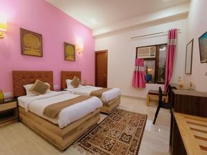 アグラにあるThe Hideout Agra - Boutique Homestay near Tajのピンクの壁のドミトリールーム ベッド2台