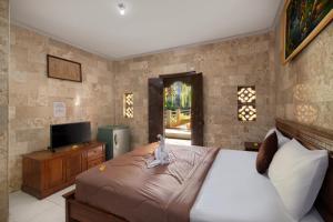 Postel nebo postele na pokoji v ubytování Hotel Lumbung Sari Legian