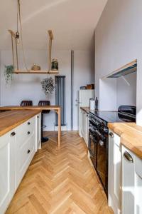 een keuken met witte kasten en een houten aanrecht bij Duplex Apartment - City Centre in Chester