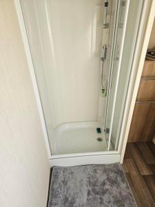 a shower with a glass door in a bathroom at Woods caravan in Ingoldmells
